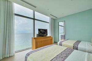 a hotel room with two beds and a large window at Hotel H2O in Manila