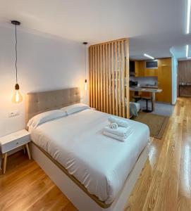 a bedroom with a large bed with towels on it at Las Terrazas de Vigo in Vigo