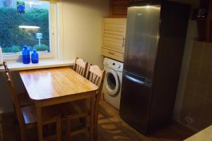 a kitchen with a table and a refrigerator at Männi Holiday House in Haapsalu