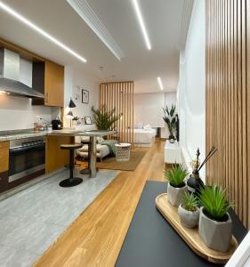 eine Küche und ein Wohnzimmer mit einem Tisch und Topfpflanzen in der Unterkunft Las Terrazas de Vigo in Vigo
