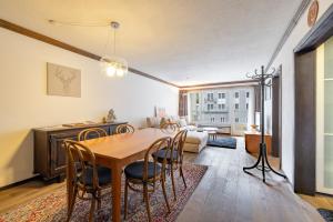 uma sala de jantar com mesa e cadeiras e uma sala de estar em Au Reduit em St. Moritz
