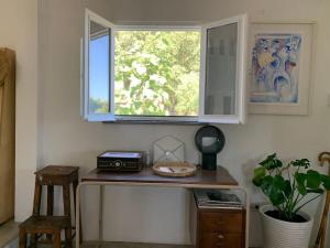 a room with a table with a window and a counter with aisk at Property between Melides and Aberta Nova beach in Melides