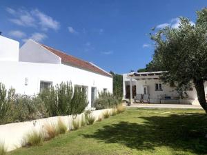 a white house with a tree and a yard at Property between Melides and Aberta Nova beach in Melides