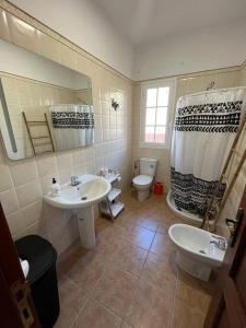 a bathroom with two sinks and a toilet and a shower at Chalet. Jardín, vistas, tranquilidad in Caleta de Interián