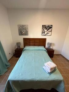 a bedroom with a bed with a green comforter at Chalet piscina privada max 26º Jardín, tranquilidad in Garachico