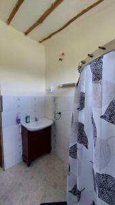a bathroom with a sink and a shower curtain at BlackOmena 