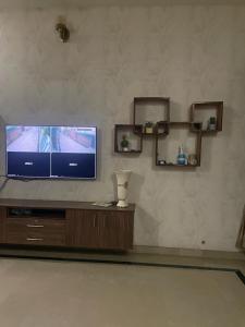 een woonkamer met een televisie op een houten entertainmentcentrum bij Warraich villa gt raod gujrat entire in Gujrāt