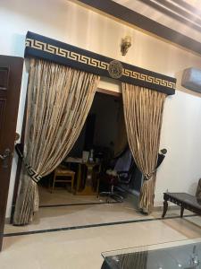 - un salon avec des rideaux sur un mur dans l'établissement Warraich villa gt raod gujrat entire, à Gujrāt