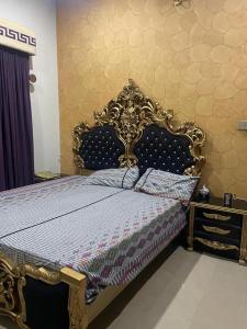 una camera da letto con letto dotato di telaio dorato di Warraich villa gt raod gujrat entire a Gujrāt