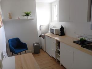 a kitchen with a counter and a blue chair at Appartement cosy plein centre in Conches-en-Ouche