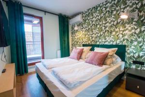 a large bed in a room with a green wall at SPA Waterlane Island Deluxe 2 by Grand Apartments in Gdańsk