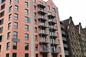 a tall apartment building with balconies on the side of it at SPA Waterlane Island Deluxe 2 by Grand Apartments in Gdańsk