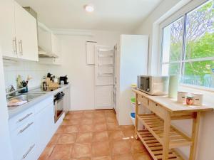 Η κουζίνα ή μικρή κουζίνα στο Snug Stays 1 I 3-Zimmer Design Apartment am See mit Garten I Home Office I Highspeed Wifi