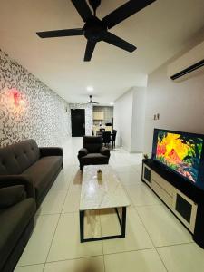 sala de estar con sofá y TV de pantalla plana en Aurora Residence Puchong Prima, en Puchong