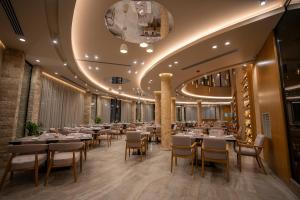 comedor con mesas y sillas y techo en Duomo Resort en Shkodër