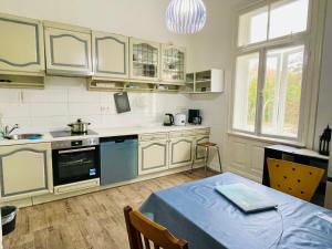 a kitchen with white cabinets and a table with a blue table cloth at Hamburg Billstedt Center in Hamburg