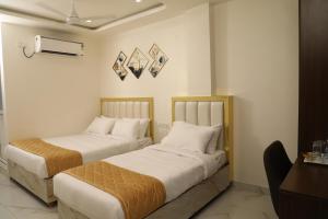 duas camas sentadas uma ao lado da outra num quarto em The Nectar Hotel em Hyderabad