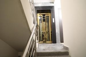 uma escada com um elevador de ouro num edifício em The Nectar Hotel em Hyderabad