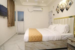 um quarto com uma grande cama branca e uma televisão em The Nectar Hotel em Hyderabad