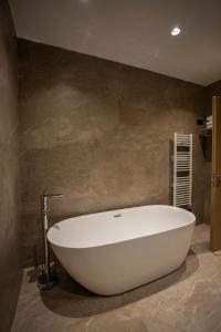 a large white bath tub in a bathroom at Duomo Resort in Shkodër