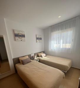 2 Betten in einem kleinen Zimmer mit Fenster in der Unterkunft Beautiful Condado Naranjos 5-447 in El Romero