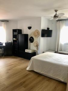 Schlafzimmer mit einem weißen Bett und Holzboden in der Unterkunft Habitación con Smart tv en piso compartido con baño privado o compartido Malaga Sol in Málaga