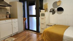 a bedroom with a bed and a kitchen with a window at Park Güell estudio in Barcelona