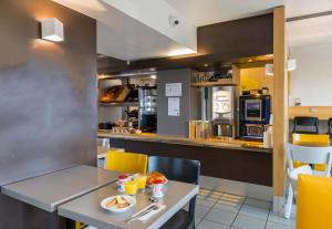 ein Restaurant mit einem Tisch mit einem Teller Essen in der Unterkunft B&B HOTEL Orléans in La Chapelle-Saint-Mesmin
