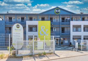 un edificio con una señal delante de él en B&B HOTEL Orléans, en La Chapelle-Saint-Mesmin