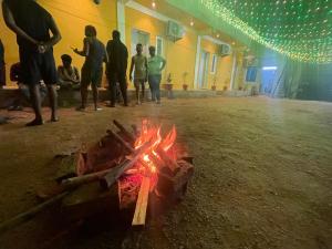 un grupo de personas de pie alrededor de un fuego en una habitación en Selvas Eden Resort with river view near boat house, en Pondicherry