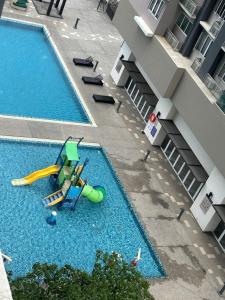 una piscina vacía con un parque infantil junto a un edificio en Aurora Residence Puchong Prima, en Puchong
