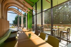 a restaurant with wooden tables and chairs and large windows at Hotel Gergana - Ultra All Inclusive in Albena