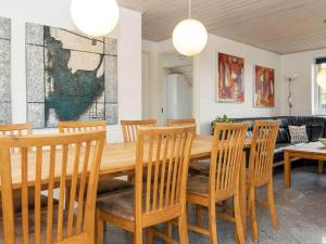 een eetkamer met een houten tafel en stoelen bij 10 person holiday home in Ulfborg in Ulfborg