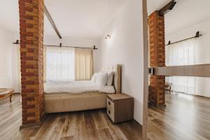 a bedroom with a bed and a brick wall at Cazare Zorilor in Zărneşti