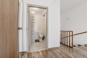 a bathroom with a toilet in a room with white walls at Cazare Zorilor in Zărneşti +24 photos