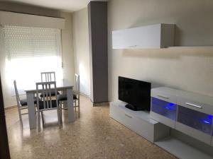 ein Wohnzimmer mit einem TV und einem Esstisch in der Unterkunft Alojamiento Mirasierra 2 in Torre del Campo