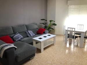 ein Wohnzimmer mit einem Sofa und einem Tisch in der Unterkunft Alojamiento Mirasierra 2 in Torre del Campo