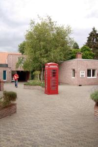 una cabina de teléfono rojo en un camino de ladrillo en Room in Apartment - Condo Gardens Leuven - Student Flat Semiduplex, en Lovaina