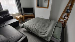 a bedroom with a bed and a couch and a television at Leicester Street in Burton upon Trent