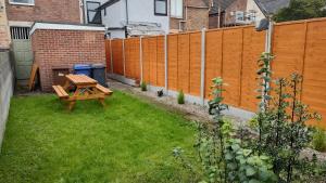 un patio trasero con una mesa de picnic y una valla en Leicester Street en Burton upon Trent