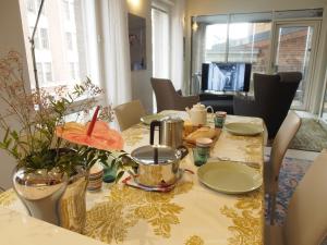 Luxury City Seafront Apartment with Balcony في هلسنكي: طاولة طعام مع طاولة قماش صفراء وبيضاء