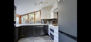 a kitchen with white cabinets and a large window at Meadowcroft in Lindale