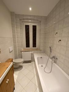 uma casa de banho branca com uma banheira e um WC em Pension Anna em Löbau