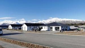 uma fila de casas numa rua com montanhas cobertas de neve em 37 Galaxy A em Lake Tekapo