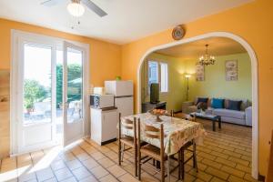 a kitchen and dining room with a table and a room at Le Soleil Occitan - A 20min du Viaduc de Millau in Castelnau-Pégayrols