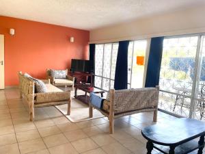 Una sala de estar con un sofá y sillas y un televisor. en 2 Bedroom Sea View Apartment, en Mombasa