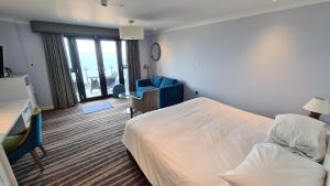 una camera d'albergo con letto, scrivania e sedia di St George's Hotel - Llandudno a Llandudno