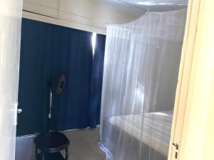 baño con ducha con pared azul en 2 Bedroom Sea View Apartment, en Mombasa 3 fotos más