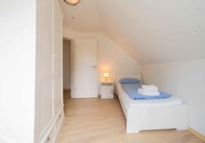 um quarto com uma cama branca num sótão em Ferienwohnung Kaufmann 3 em Rabenkirchen-Faulück