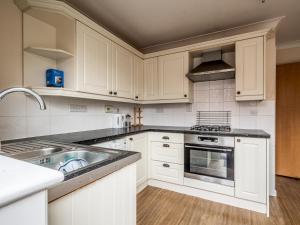 una cocina con armarios blancos y fregadero en Pass the Keys Central townhouse with parking and modern finish, en Exeter